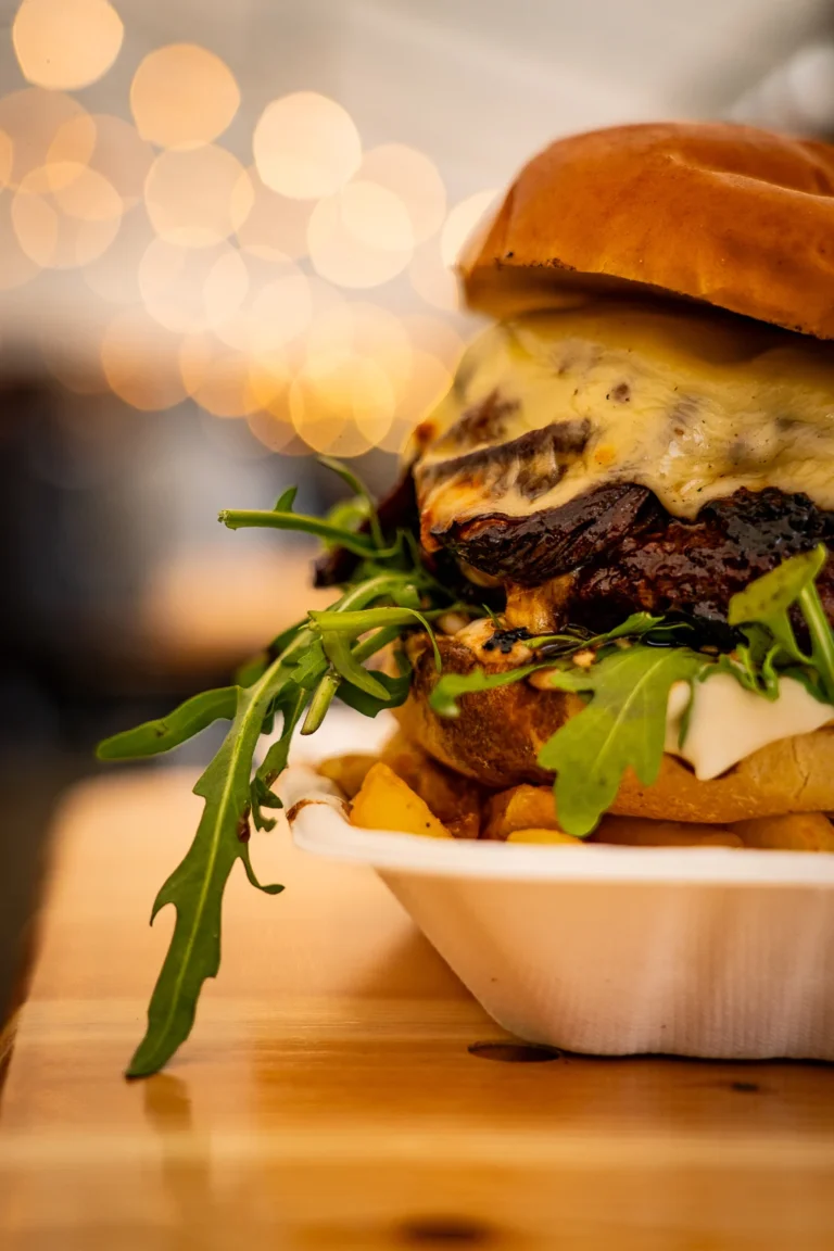 Close-up of a cheeseburger with rocket in a tray at a street food event