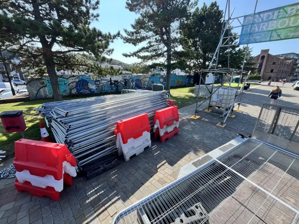 Steel crowd barriers and red water-filled barriers stacked ready for an event set-up