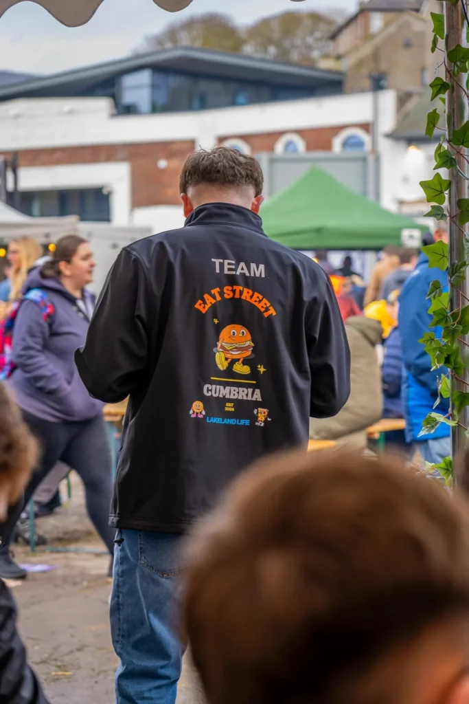Male team member of Eat Street Cumbria at the event surrounded by people
