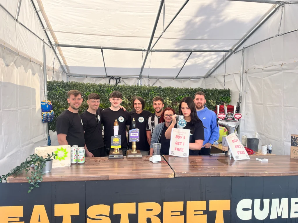 Bar team behind a branded event bar in a marquee